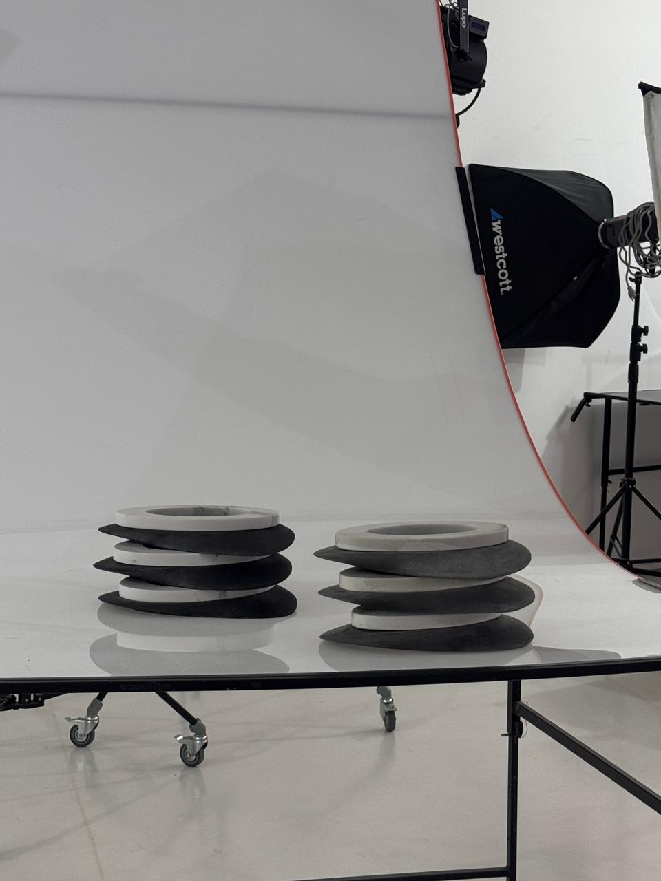 Dos pilas de platos de mármol y concreto sobre una mesa en un set fotográfico