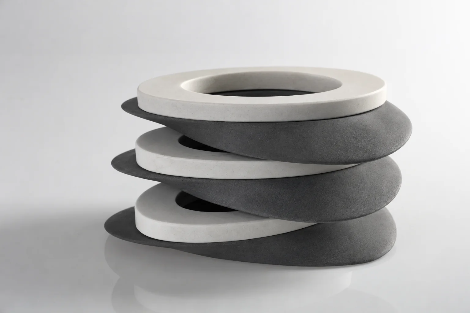 FUSO tono +0.2: tres platos apilados, de blanco liso y concreto gris